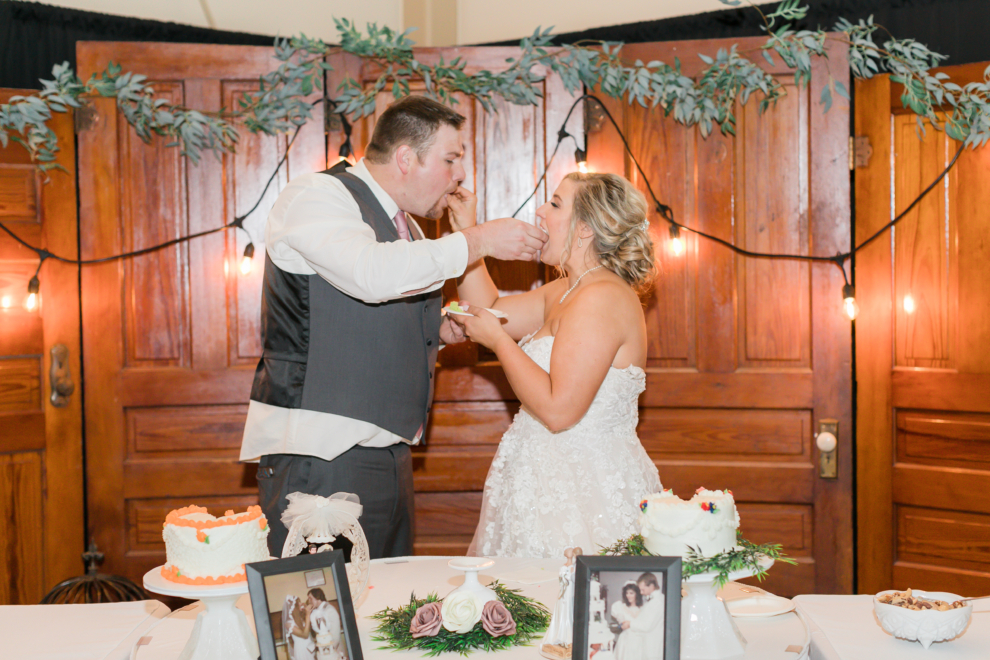 Bride and groom feeding each other cake during their wedding reception at the Fairfield Arts & Convention Center in Fairfield, Iowa.