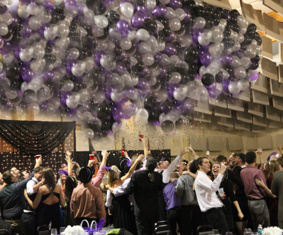 Guests celebrating under a large balloon drop during a wedding reception at the Fairfield Arts & Convention Center in Fairfield, Iowa.