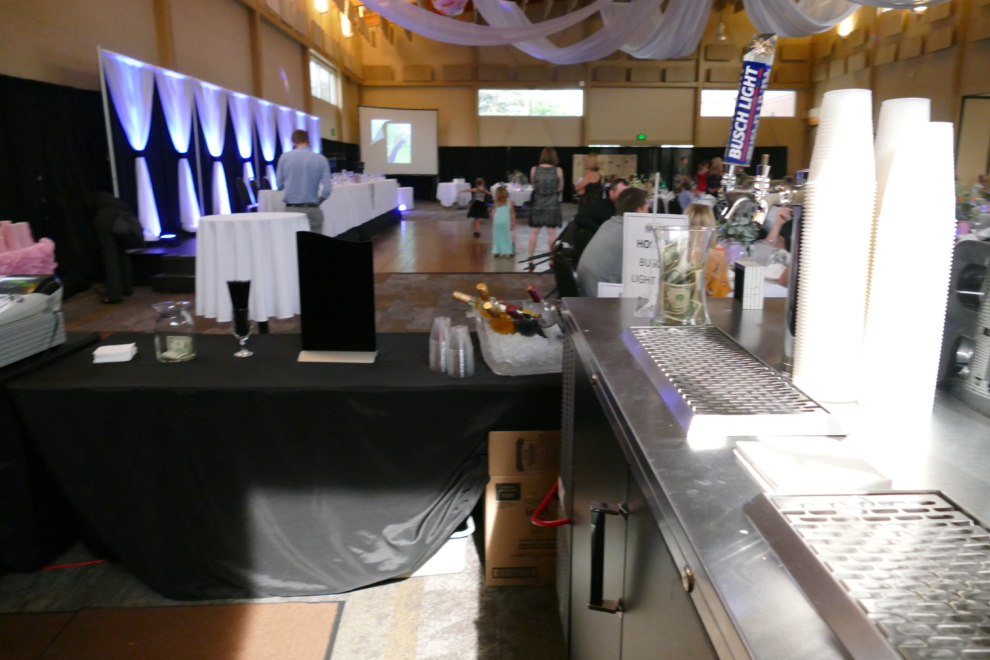 View from the FACC bar into a decorated wedding reception with draping and guests in the Expo Hall.